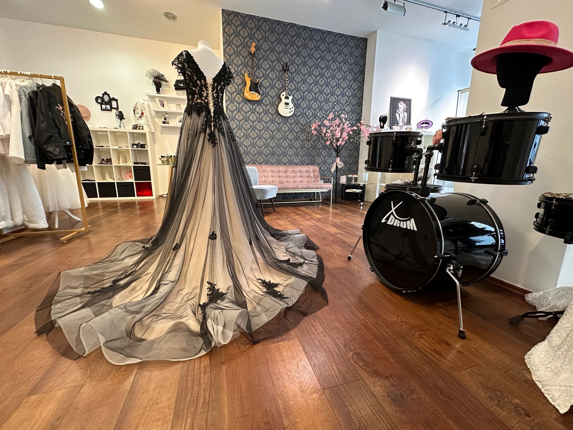 Ein schwarz-weißes Kleid liegt auf einem Holzboden neben einem Schlagzeug.