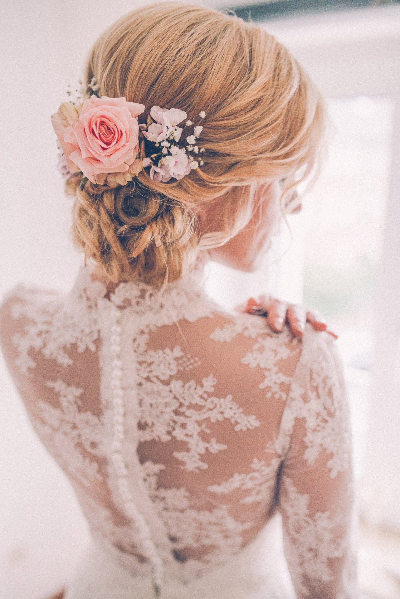 Eine Frau in einem Brautkleid mit einer Blume im Haar.
