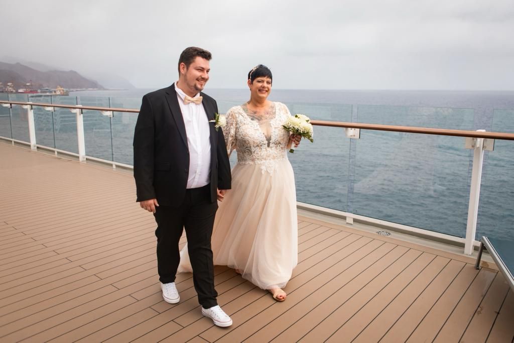 Eine Braut und ein Bräutigam gehen auf dem Deck eines Kreuzfahrtschiffes spazieren.