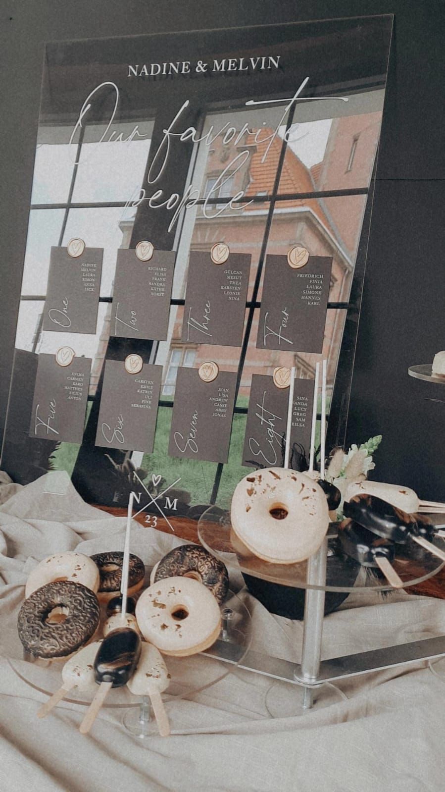 Ein Tisch mit einem Sitzplan und Donuts darauf.