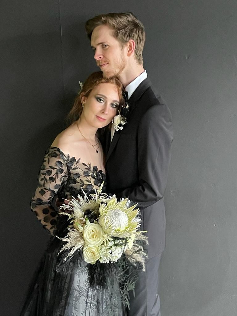 Die Braut trägt ein schwarzes Kleid und der Bräutigam einen schwarzen Anzug.