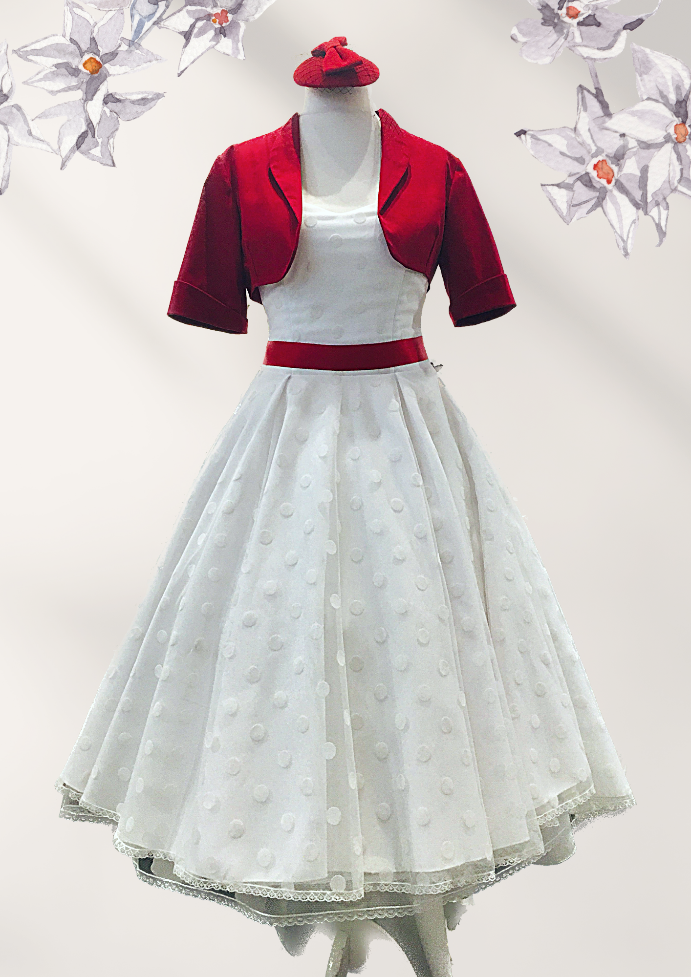 Ein weißes Kleid mit einer roten Jacke auf einer Schaufensterpuppe