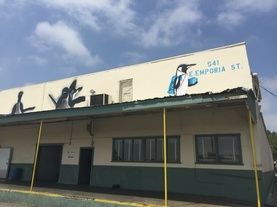 A building with a painting of a bird on the side of it.