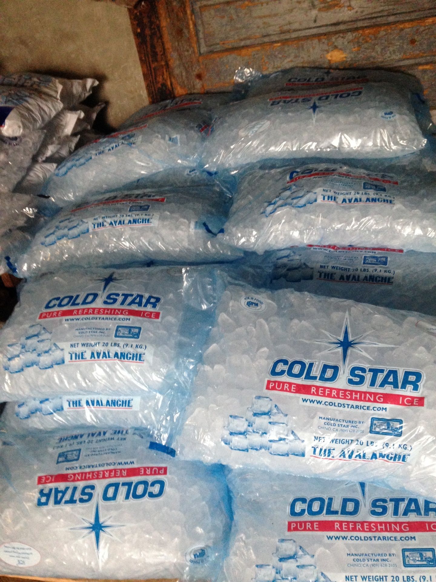 A bunch of bags of ice are stacked on top of each other on a table.