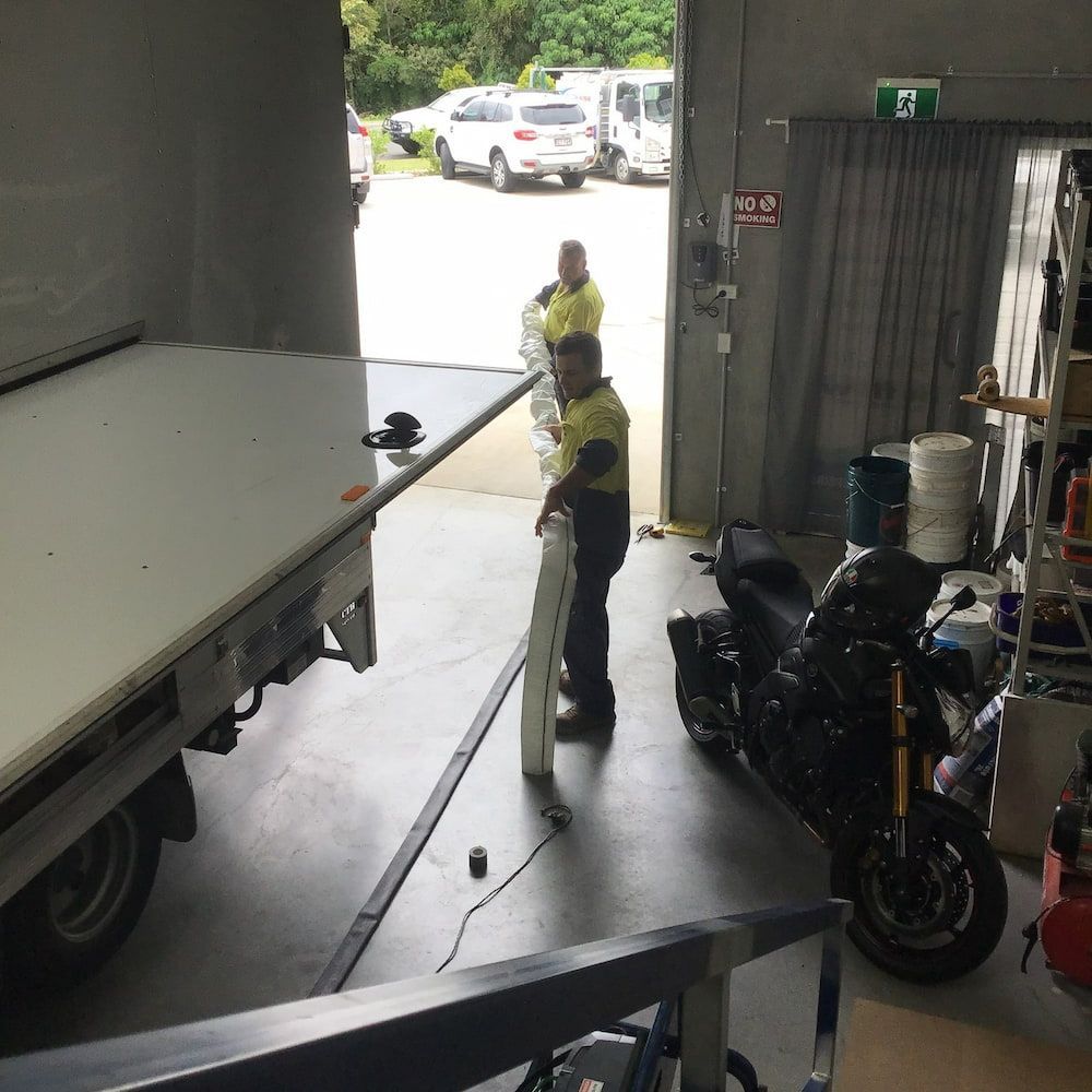 A Man is Standing in a Garage Next to a Motorcycle — FlowWise in Maroochydore, QLD
