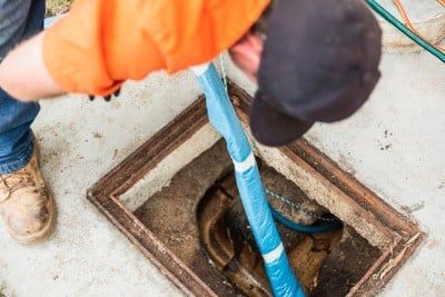 FlowWise Plumbers Cleaning a Drainage Pipe