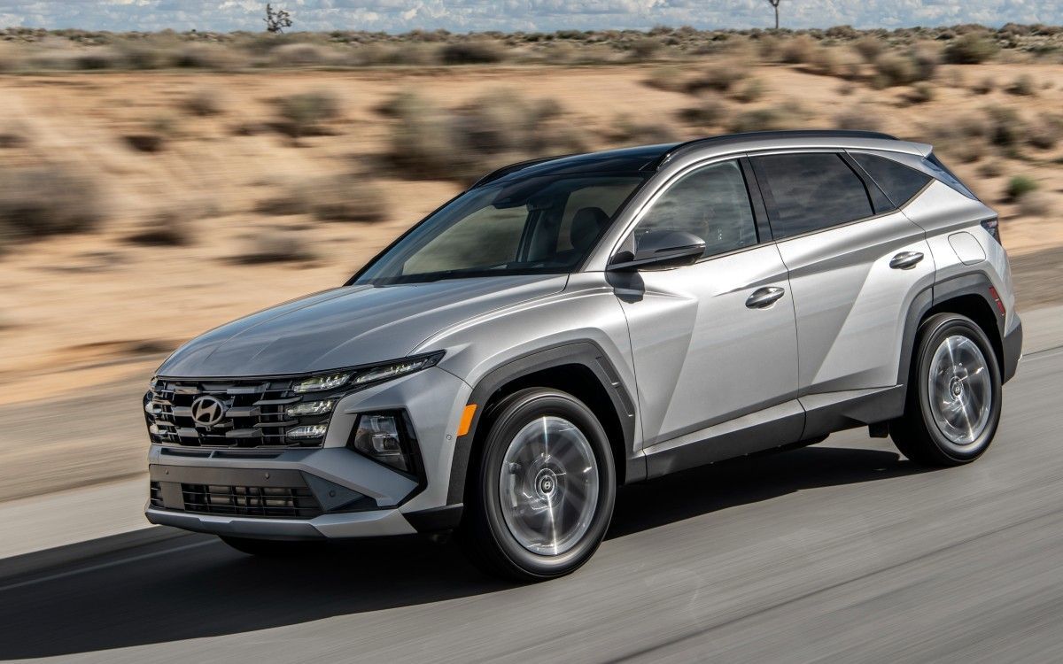 Silver SUV driving on a desert road with blurred background.