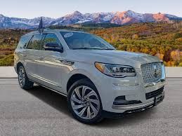 Silver SUV parked on a road with mountains in the background