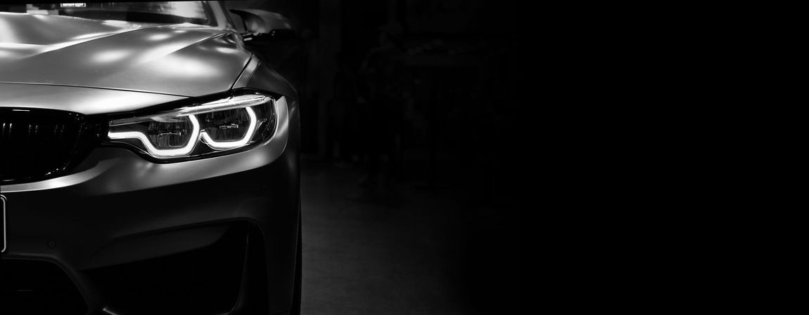 A close up of a car 's headlights in a black and white photo.