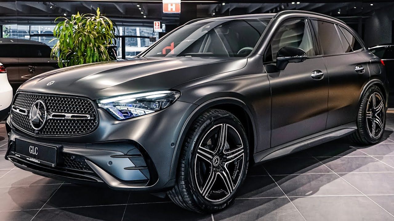 Matte black Mercedes-Benz SUV displayed in a showroom, front-left view, under bright lights
