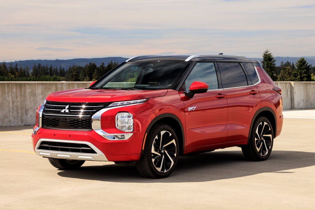 Red compact SUV parked outdoors on a concrete surface with mountains in the background