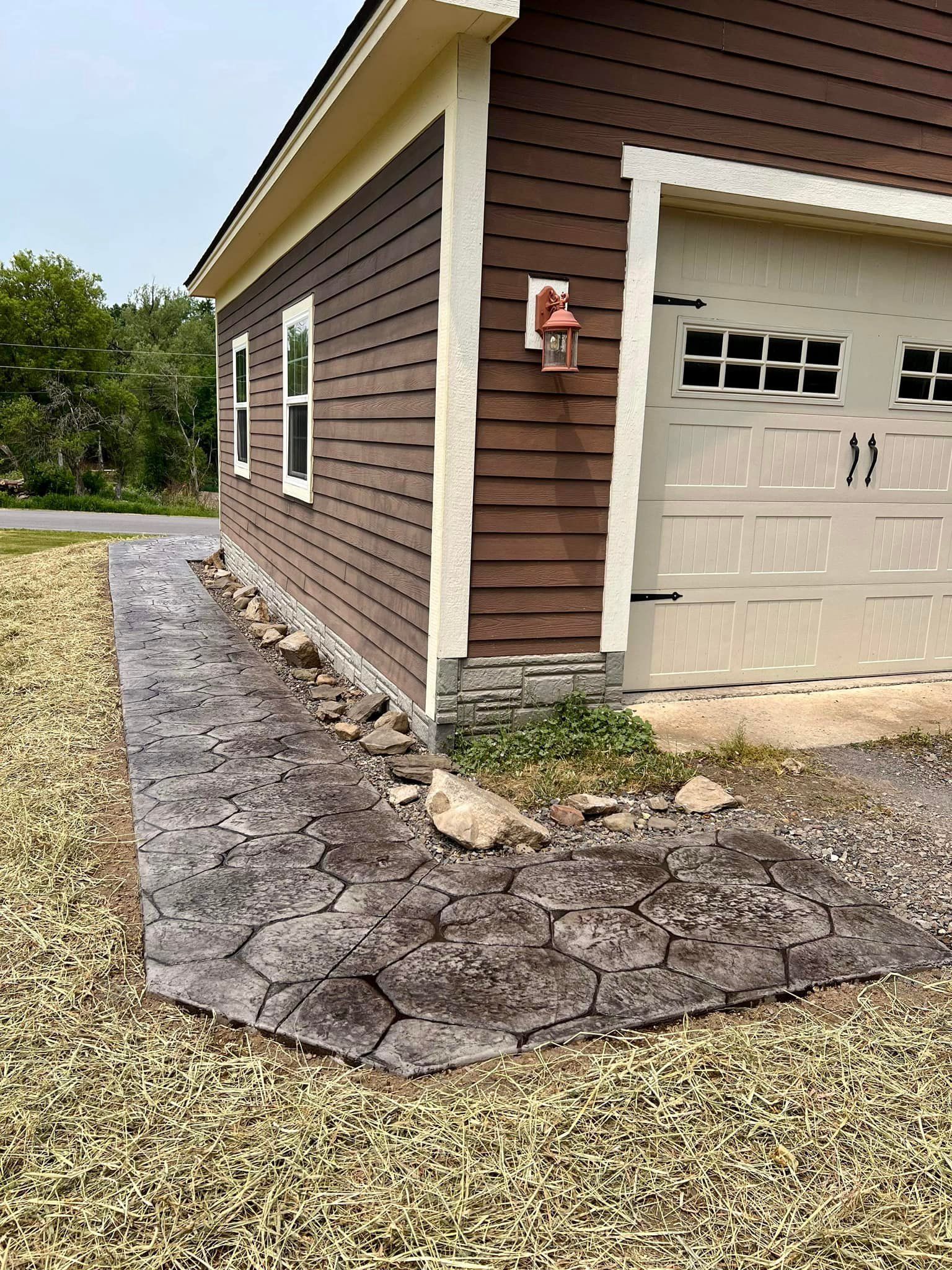Brown building with stone edging and tan garage door.