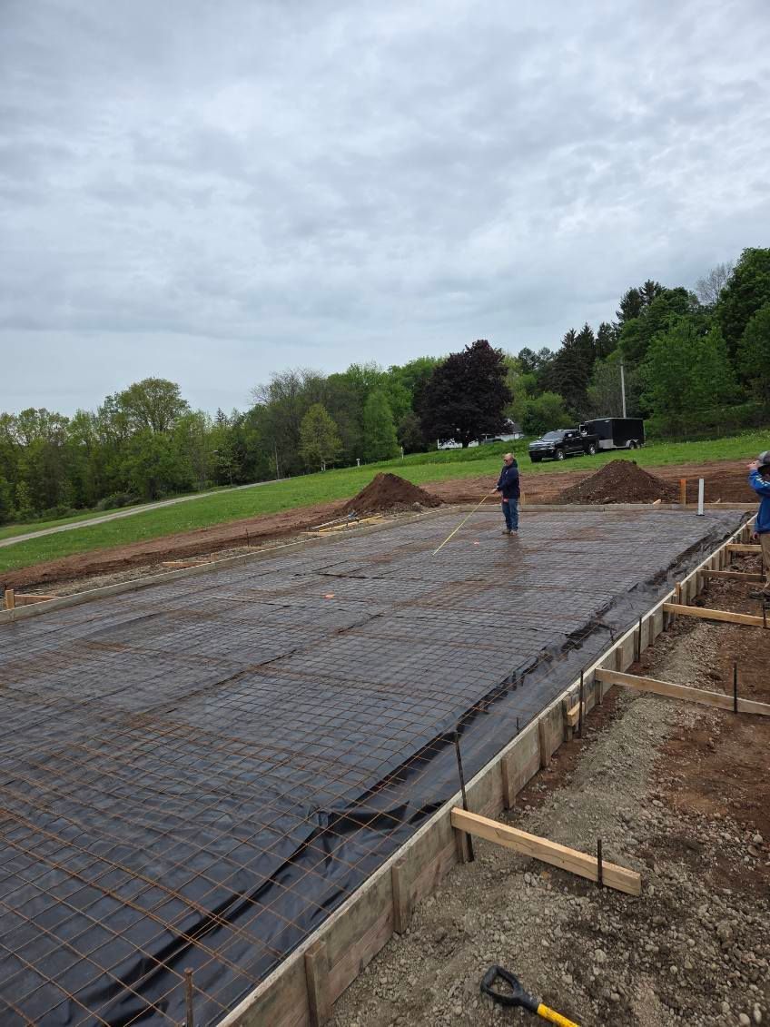 Concrete slab under construction with rebar mesh and one worker on the site