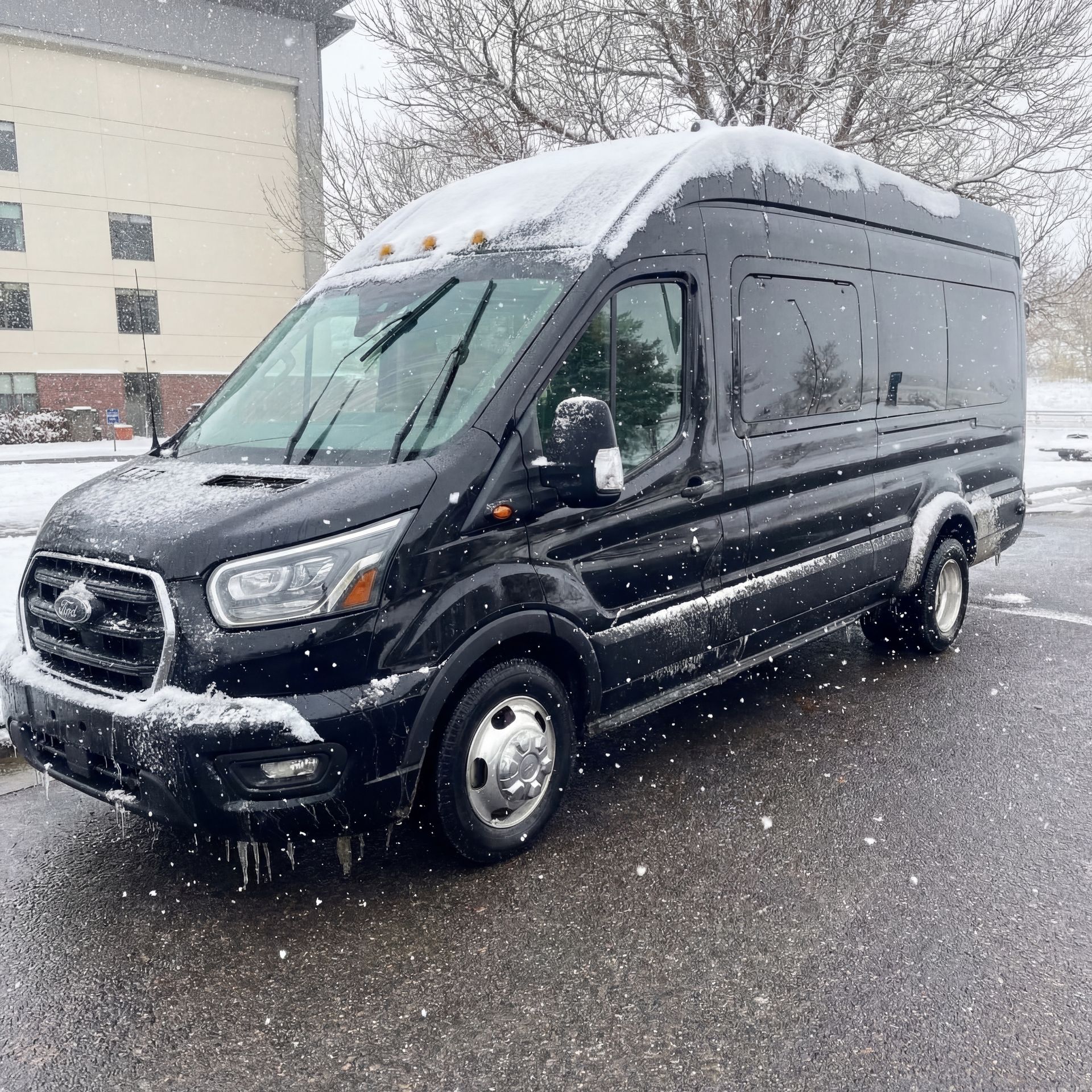 Black passenger van in a snowy outdoor setting.