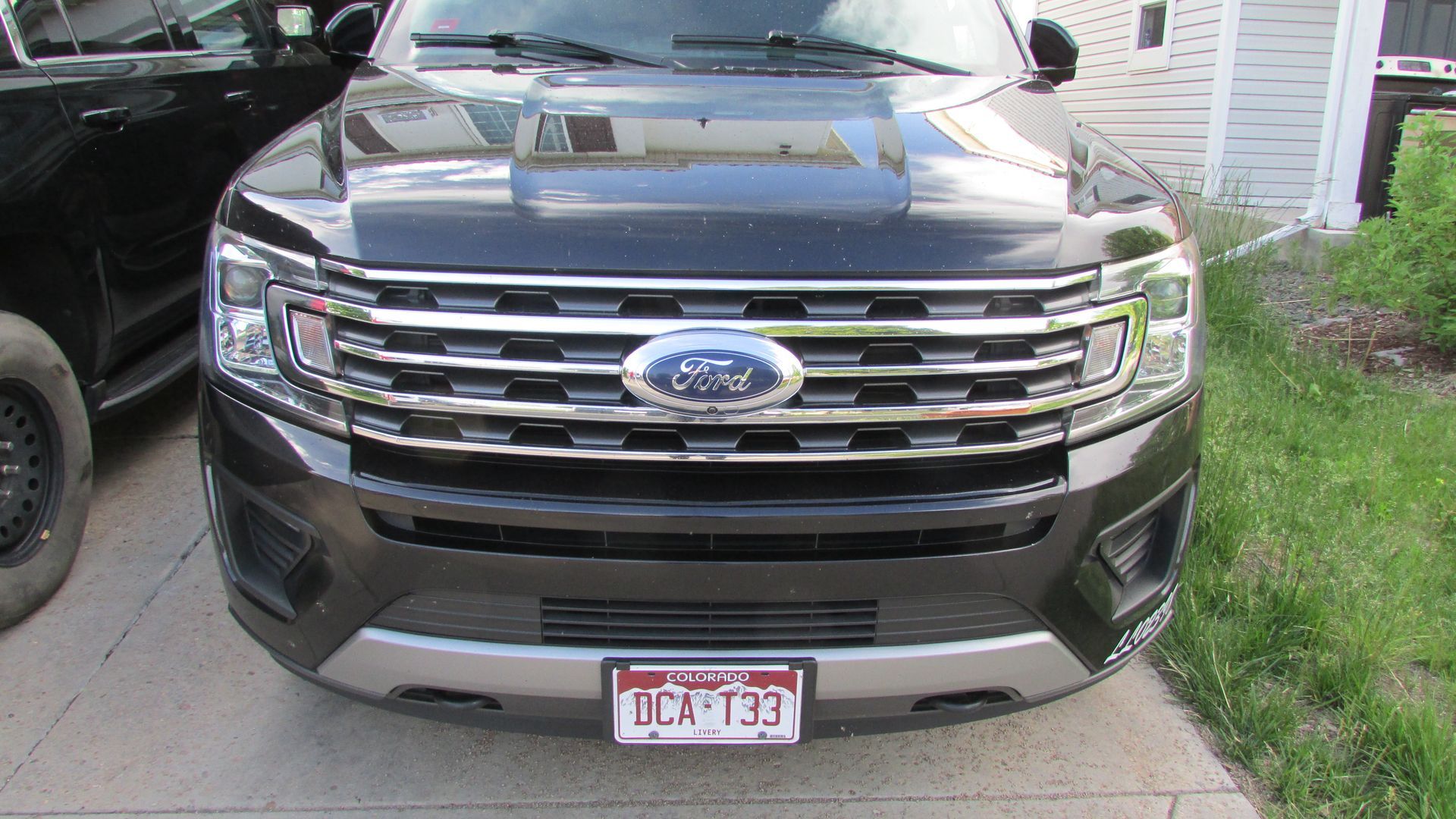 Black Ford Expedition SUV parked on a paved driveway with a license plate.