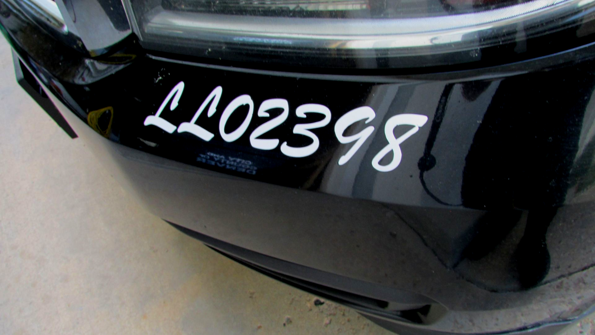 Black car bumper with white sticker reading