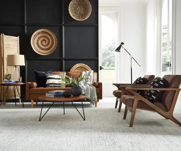 A living room with a couch , chairs , and a coffee table.