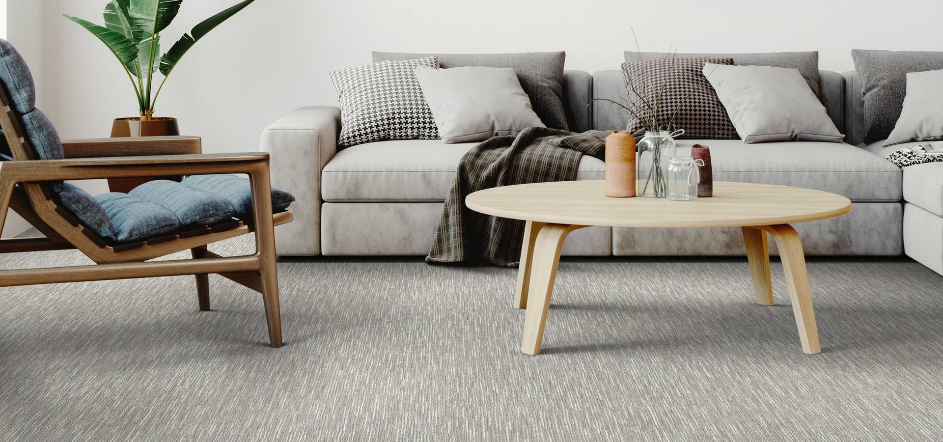 A living room with a couch , chair , coffee table and carpet.