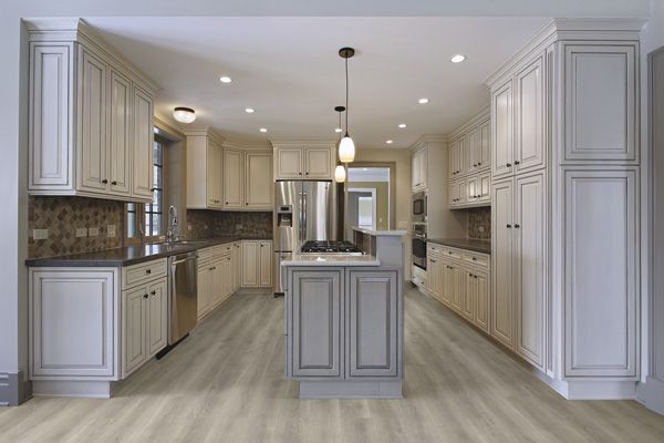 A kitchen with white cabinets and a large island in the middle.
