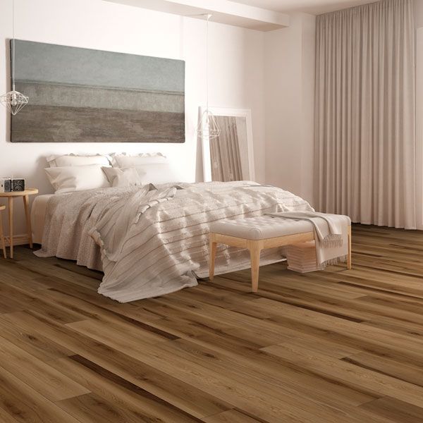 A bedroom with hardwood floors , a bed , a bench and a painting on the wall.