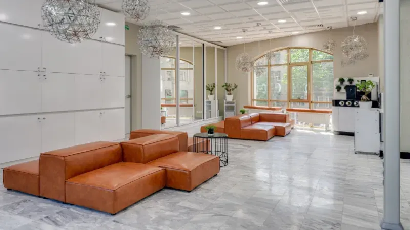 A living room with a lot of furniture and a lot of windows.