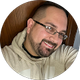 A man with a beard and glasses is smiling in a circle.