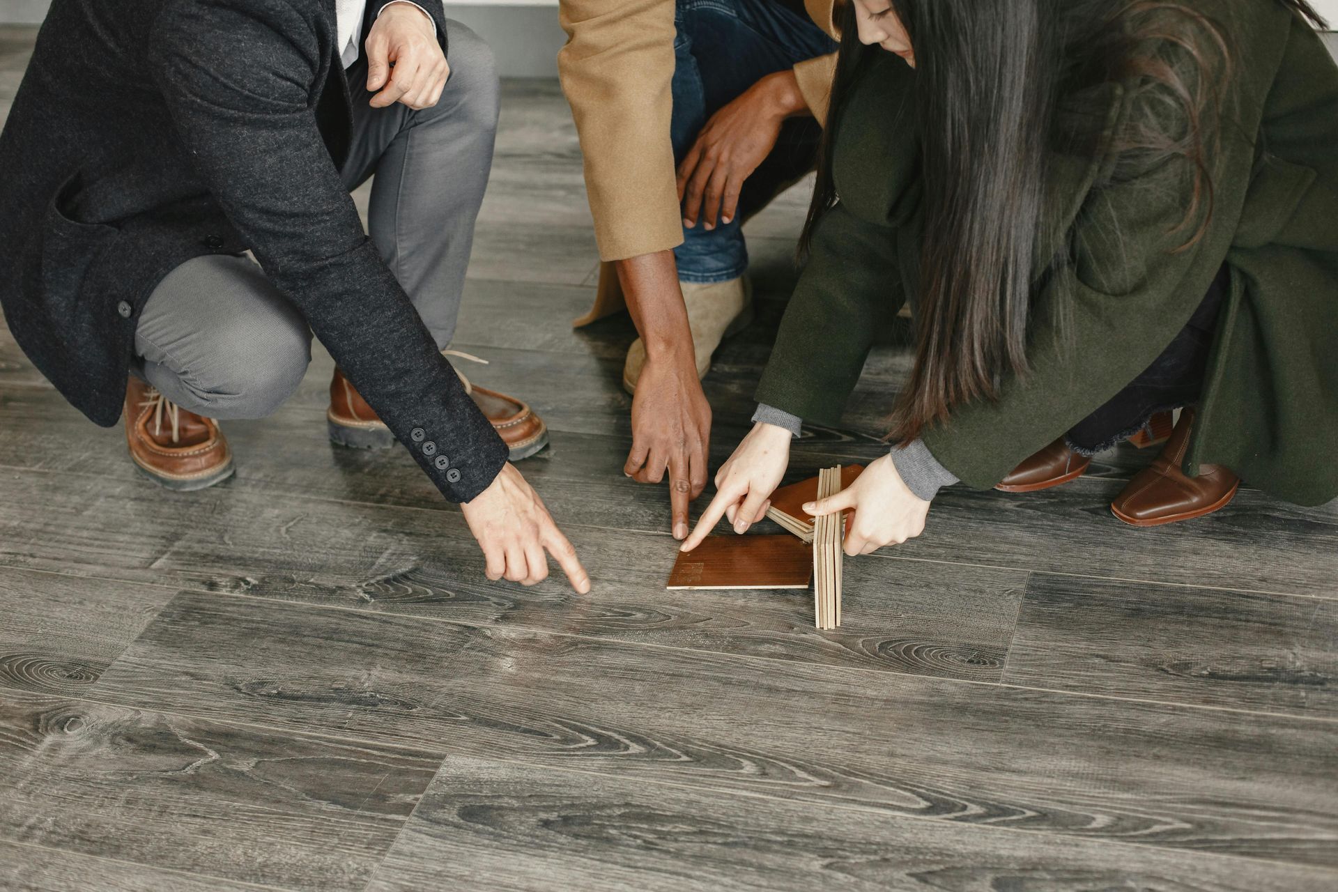 A group of people are looking at a piece of wood on the floor.