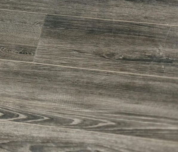 A close up of a wooden floor with a gray tile.