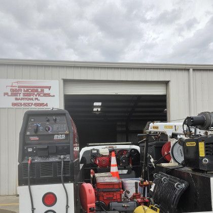 Industrial equipment and an open garage bay with trailers and machinery in front of a metal building