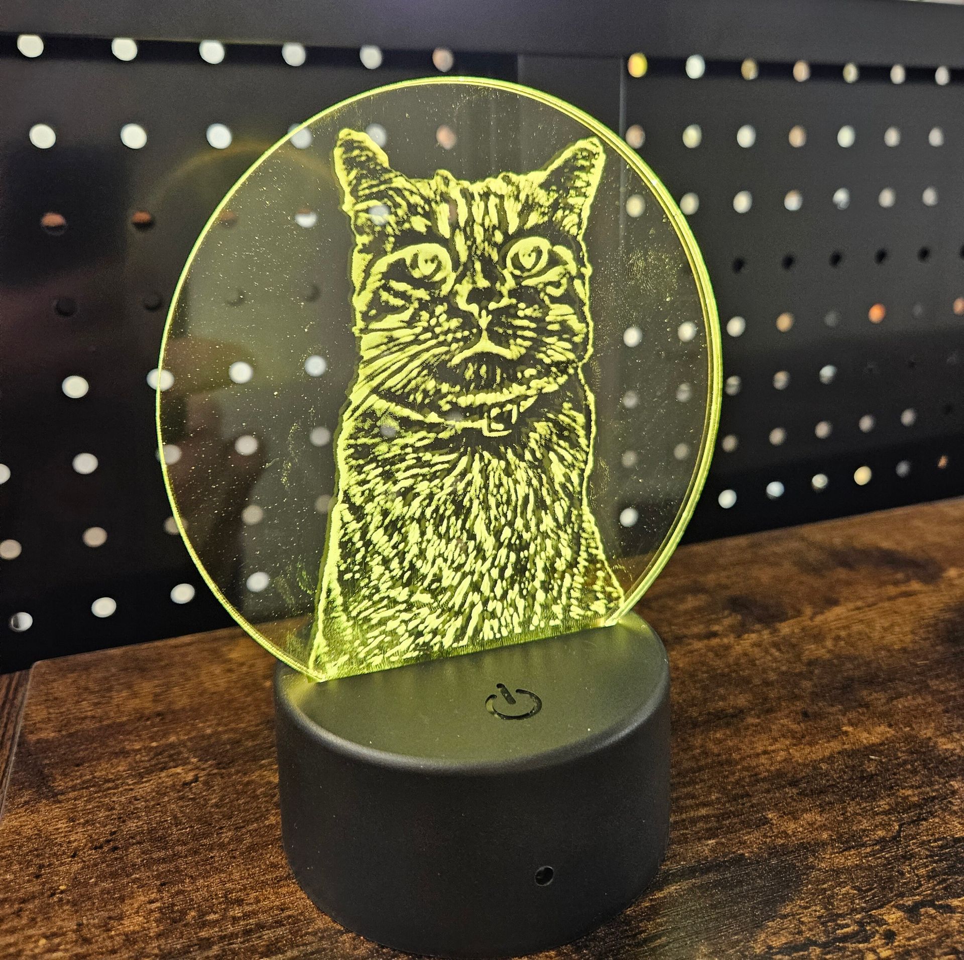 Cat illustration on a glowing yellow LED acrylic plaque with a black base, against a dotted background