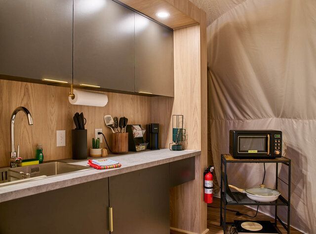 Modern bedroom with a built-in gray alcove, warm recessed lights, and a small bedside table