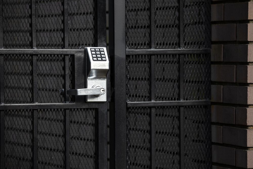 Black Metal Gate With Keypad Lock, Adjacent to a Brick Wall — Gate-O-Matic in Garbutt, QLD