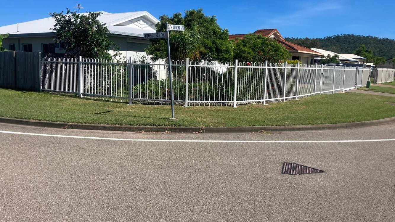 A White Metal Fence Wraps Around a Corner Lot With a House — Gate-O-Matic in Garbutt, QLD