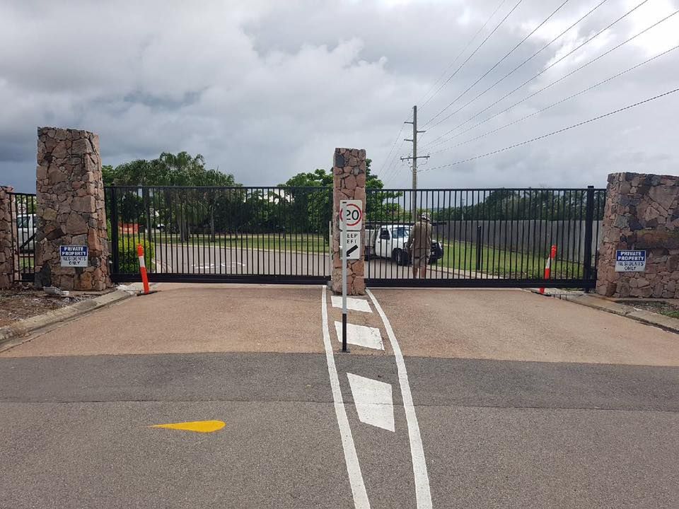 Entrance Gate With Stone Pillars, Black Metal Gates, and Road Markings. Cloudy Sky Overhead — Gate-O-Matic in Garbutt, QLD