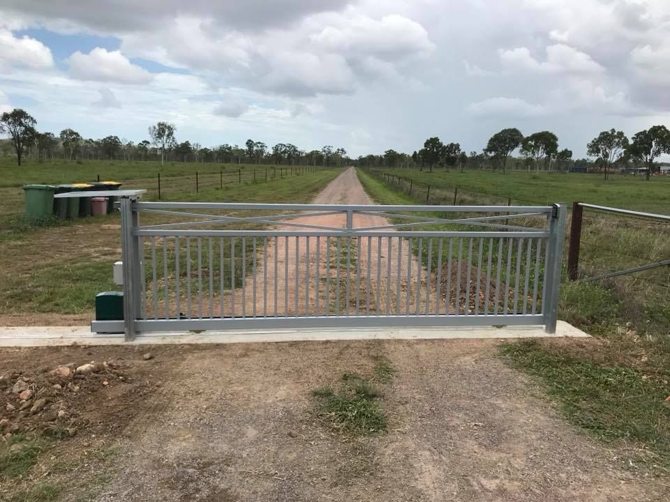 A Grey Metal Sliding Gate Installed Across a Gravel Driveway — Gate-O-Matic in Garbutt, QLD