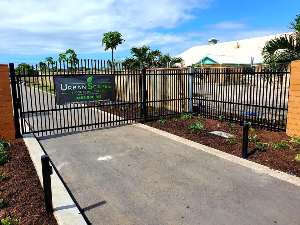 A Black Metal Gate Entrance for Urban Scape With a Paved Driveway — Gate-O-Matic in Garbutt, QLD