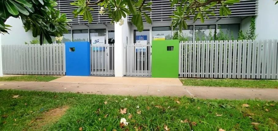 Blue, White, and Green Recycling Bins Behind a White Picket Fence on a Grassy Lawn — Gate-O-Matic in Garbutt, QLD