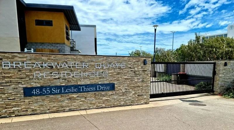 Entrance to Breakwater Shore Residences with gated entrance, stone wall, and building in background — Gate-O-Matic in Garbutt, QLD