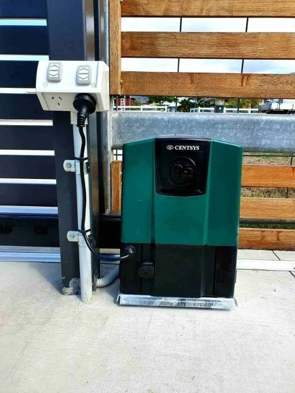 Green and Black Gate Opener With Control Box Next to a Sliding Wooden Gate — Gate-O-Matic in Garbutt, QLD