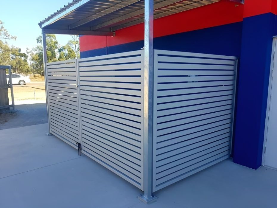 Beige Horizontal Slat Fence Alongside a Building With Red and Blue Walls — Gate-O-Matic in Garbutt, QLD