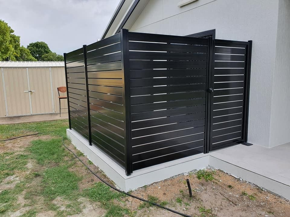 Black Horizontal Slat Fence With Gate Next to a White House; a Small Shed is in the Background — Gate-O-Matic in Garbutt, QLD