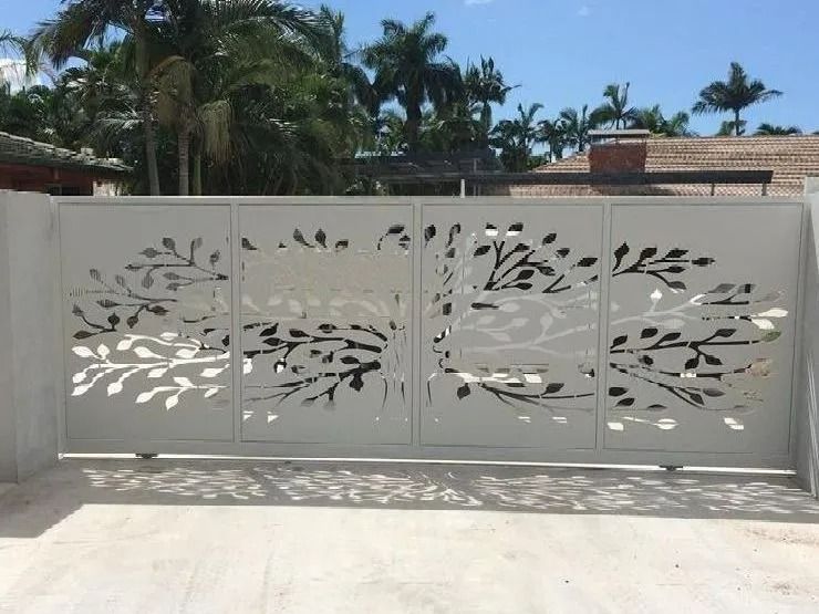Grey Metal Gate With Tree Branch Cutouts, Set in Concrete, Outdoor Setting With Palm Trees — Gate-O-Matic in Garbutt, QLD