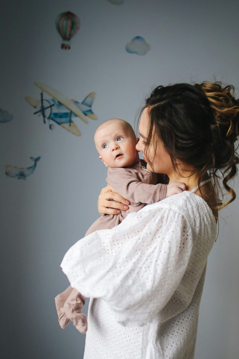 A woman is holding a baby in her arms.