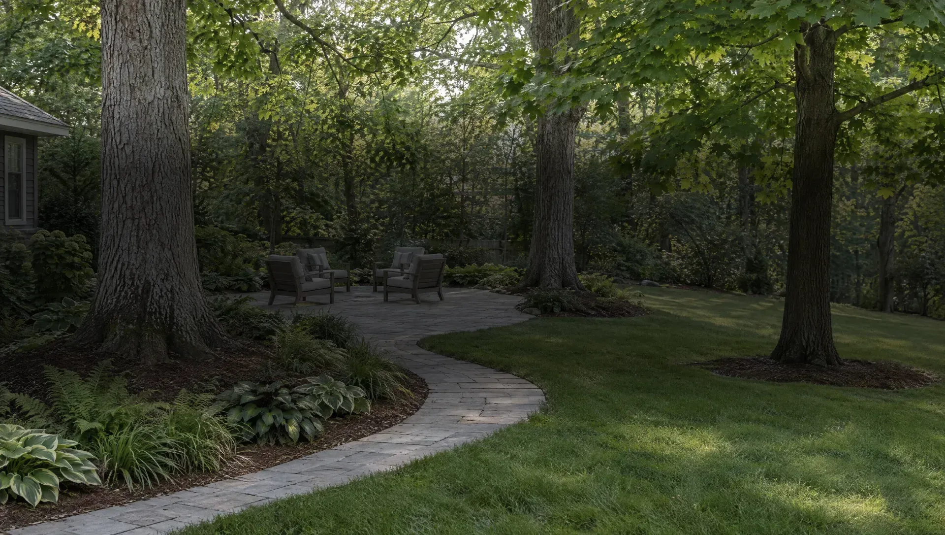 Illustration of a yard with tall trees, a curving paver path and a patio with four chairs.