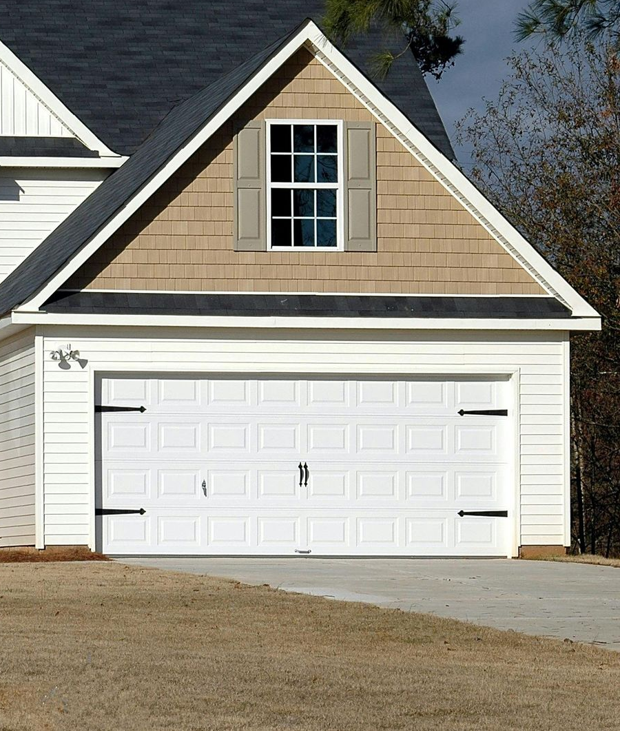 White garage door installation on a home with an architectural dormer in Orange Park.