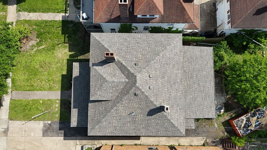 Aerial view of a gray-roofed house with a backyard lawn and neighboring homes nearby. Springfield IL.