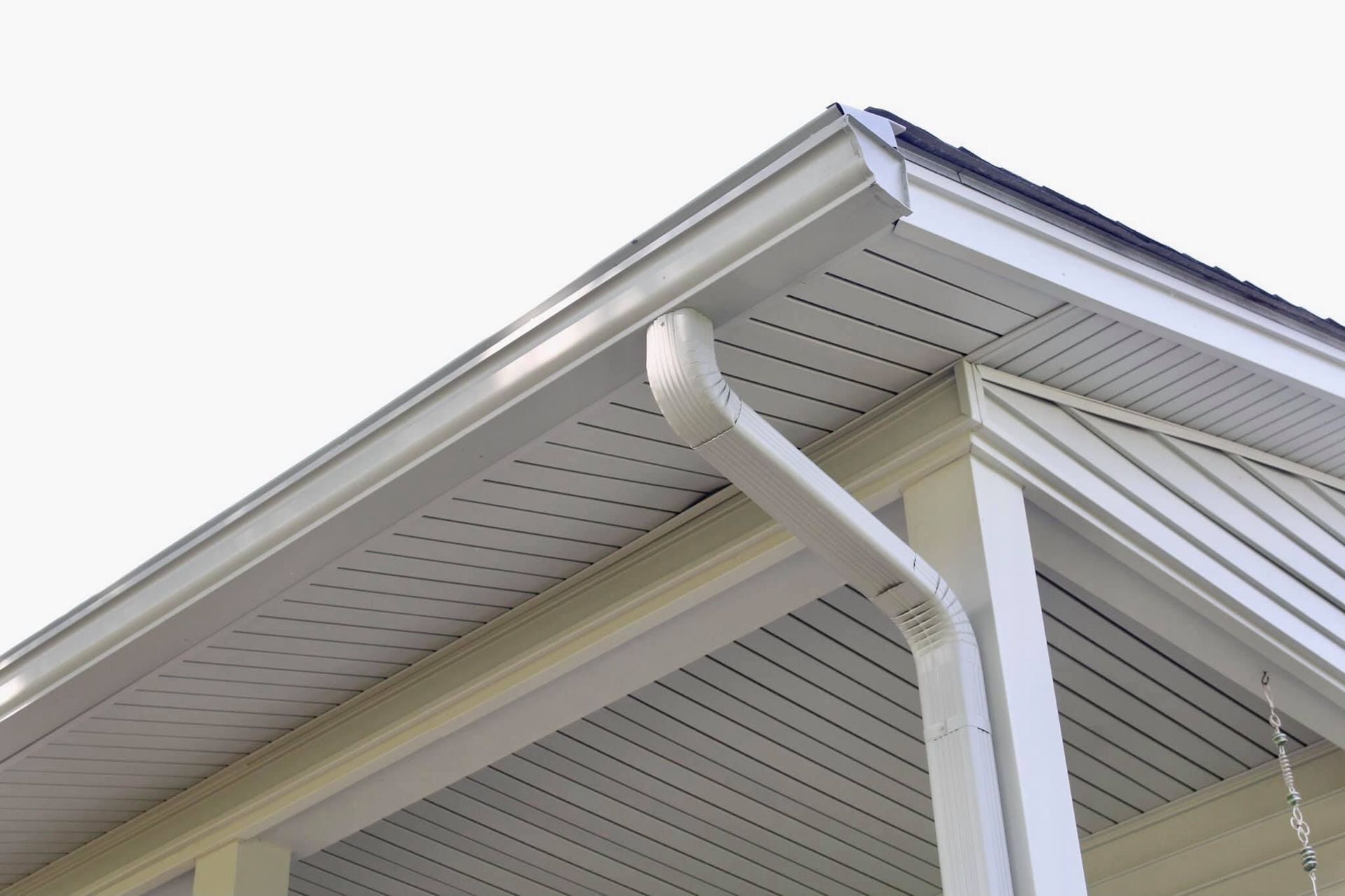 White house corner with gutter and downspout.