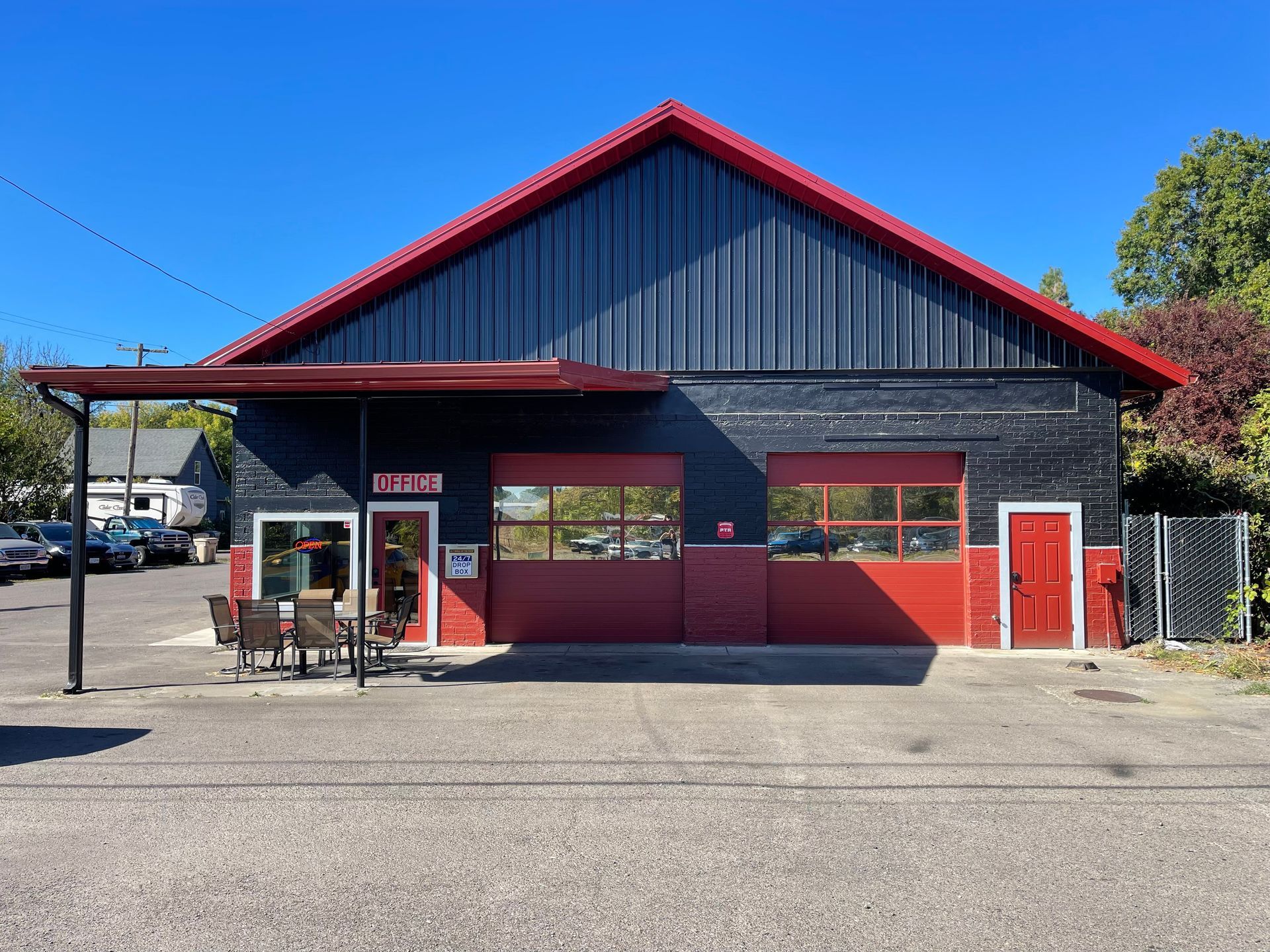 A black building with red doors and a red roof | J&H Automotive
