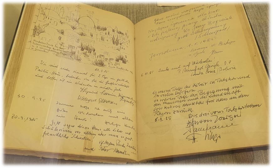 Open book with handwritten notes and a sketch on one page, aged and worn appearance.