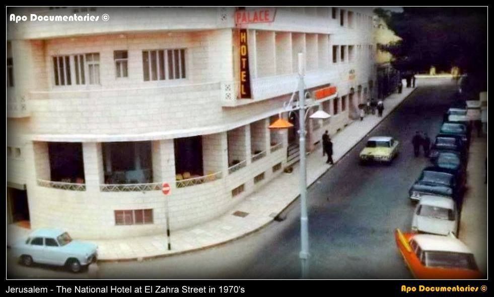 National Hotel, Jerusalem, on a street in the 1970s, with cars parked along the road and people walking.